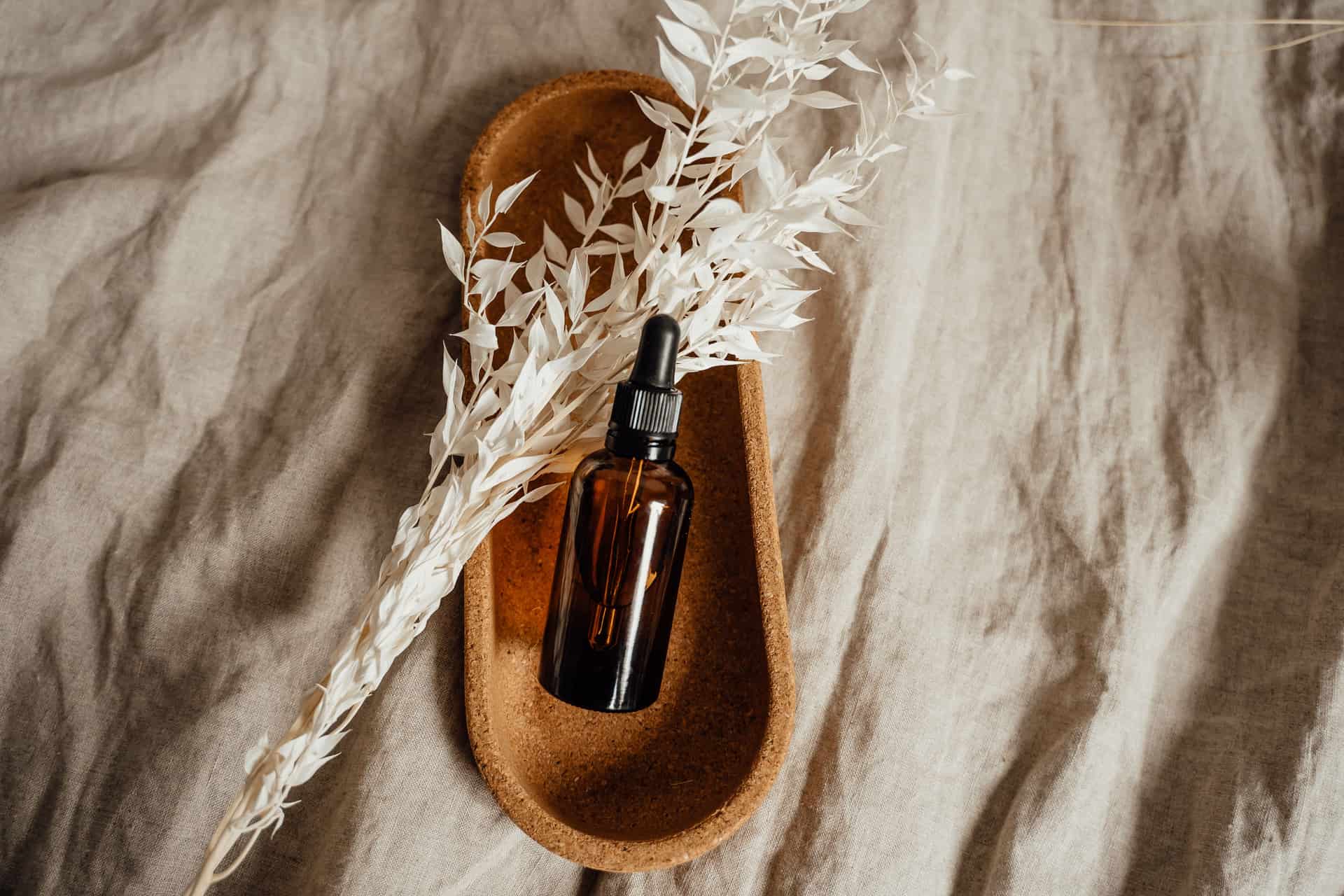 Glass pipettes and amber dropper bottles arranged on linen